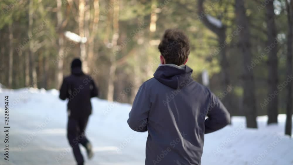 Young Male Athlete Jogging In Wintry Wood Young Male Athlete Jogging In Wintry Wood