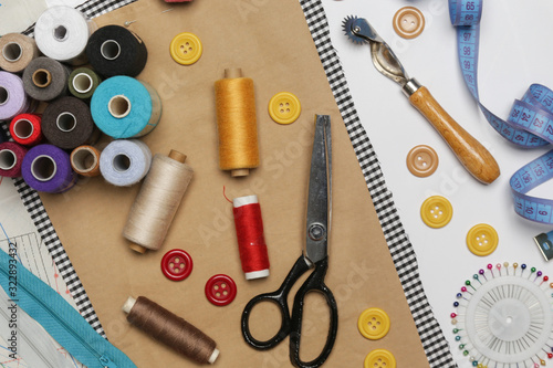 Set of different sewing items - top view of scissors, threads,buttons, sewing needles, fabric and patterns