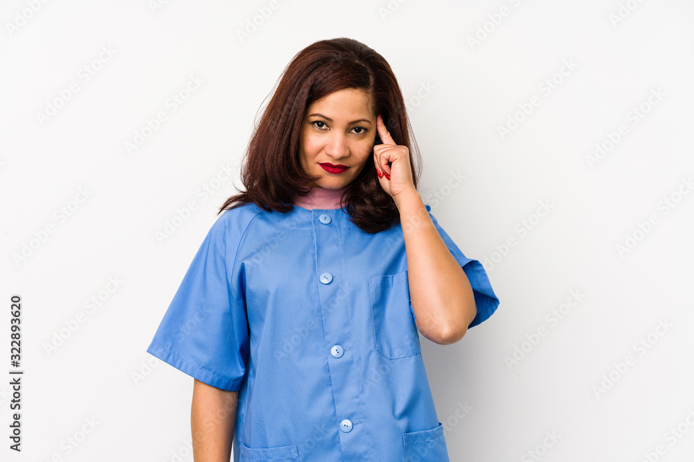 Middle age latin nurse woman isolated çpointing temple with finger, thinking, focused on a task. Middle age latin nurse woman isolated çpointing temple with finger, thinking, focused on a task.