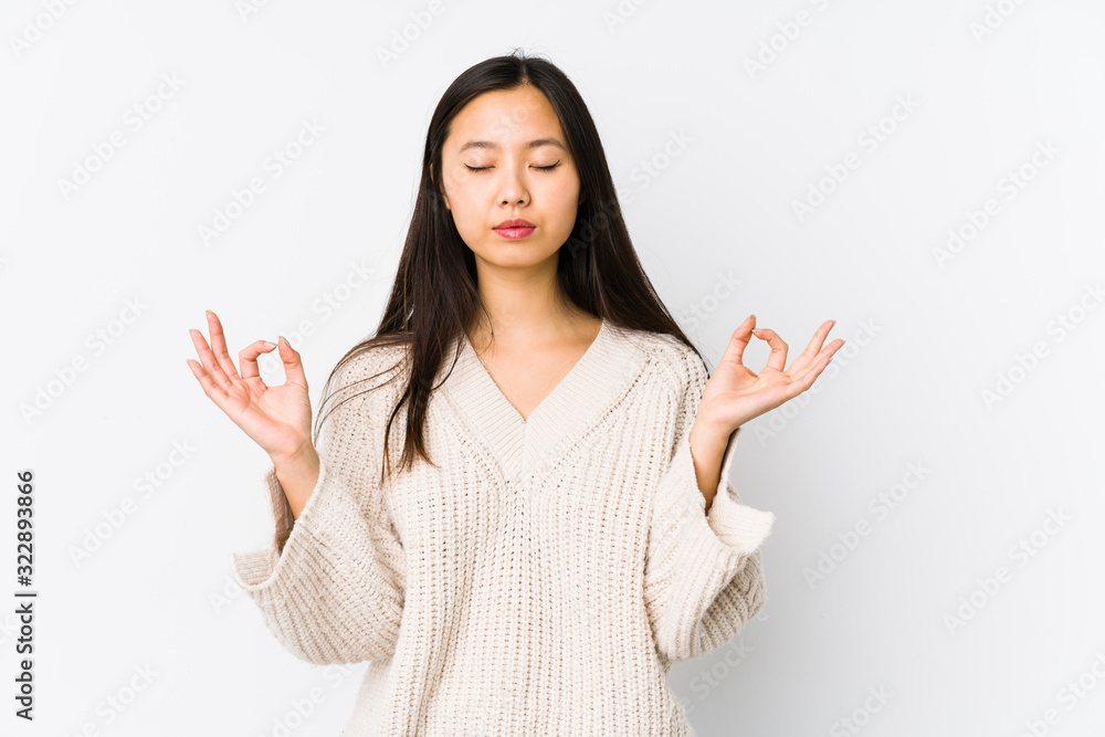Young chinese woman isolated relaxes after hard working day, she is performing yoga. Young chinese woman isolated relaxes after hard working day, she is performing yoga.