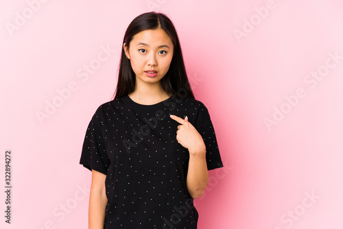 Young asian woman wearing elegant clothes isolated pointing with finger at you as if inviting come closer.