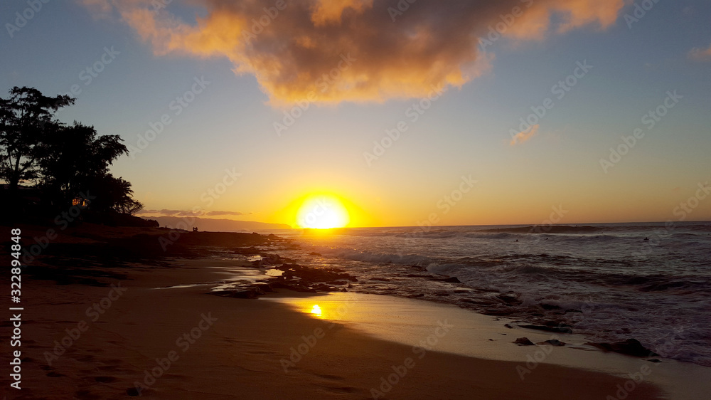 Sunset over the ocean with waves moving to shore Sunset over the ocean with waves moving to shore