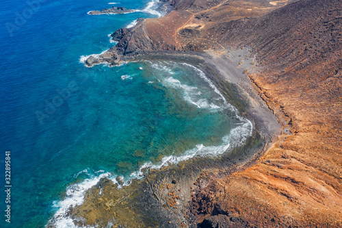 Canary Islands, Spain, october 2019: aerial view of the black beach from the top of Caldera mountain, the ancient volcano of Lobos Island Islote de Lobos , a small island 2 km north of Fuerteventura