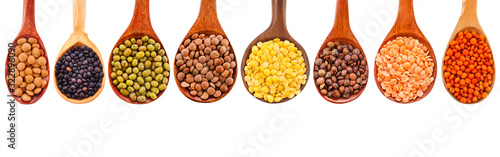 Collection of various lentils in a wooden spoons isolated on a white background. Top view. photo