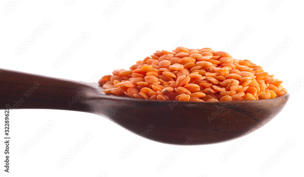 Red lentils in the wooden spoon isolated on a white background. Red lentils in the wooden spoon isolated on a white background.