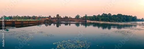 Wide Panoramic View of Entrance To World Famous Angkor Wat Khmer Temple near Siem Reap, Cambodia with Sunrise Sky in the Background