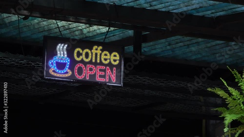 LED signs indicating the opening of the Coffee shop. Coffee cup and open message led display signs under the shop roof in the garden.