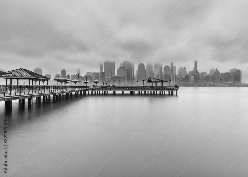 View on Financial District and J.Owen Grundy park from Hudson River on a cloudy day in black and white photo
