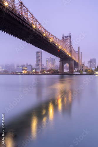 View on Queensboro bridge and Midtown manhattan on a foggy morning from East river with long exposure