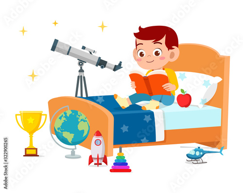 happy cute little kid boy read book in bed room