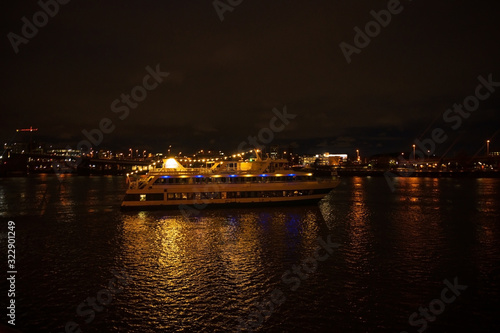 Night pleasure boat, or yacht for a walk with people. Night city with a river and a big boat © Anton