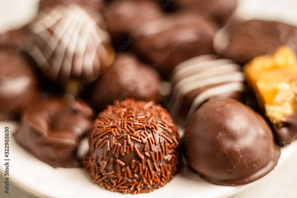 Dark chocolates, shallow depth of field focus on a sprinkly chocolate treat Dark chocolates, shallow depth of field focus on a sprinkly chocolate treat