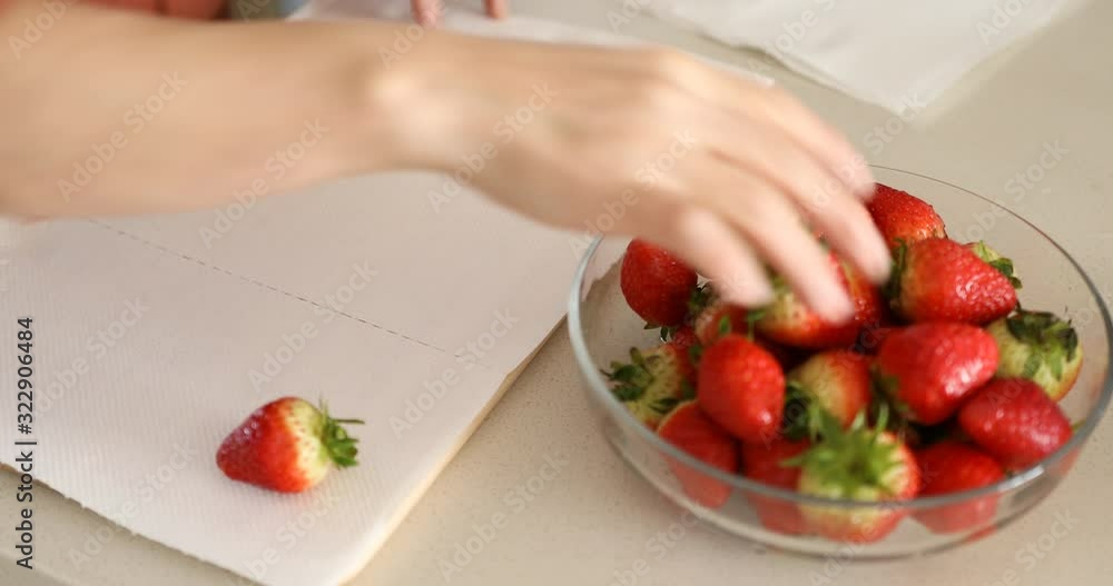 Wiping the water off the strawberries with a kitchen towel Wiping the water off the strawberries with a kitchen towel