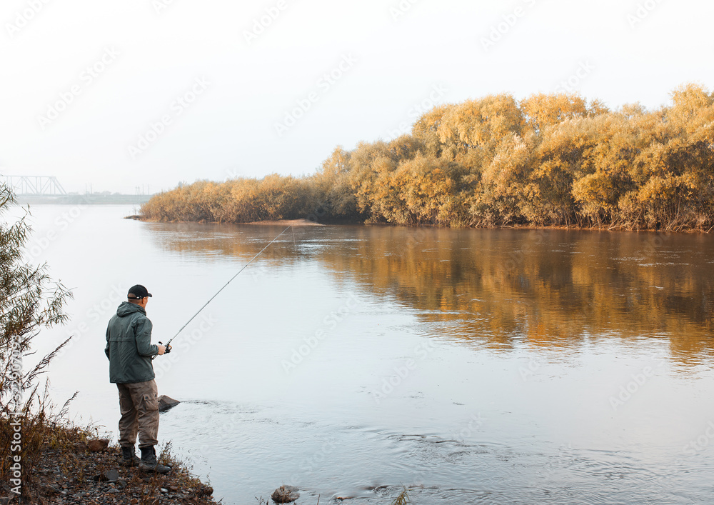 A man is fishing on the river. Fisherman on a morning fishing trip A man is fishing on the river. Fisherman on a morning fishing trip