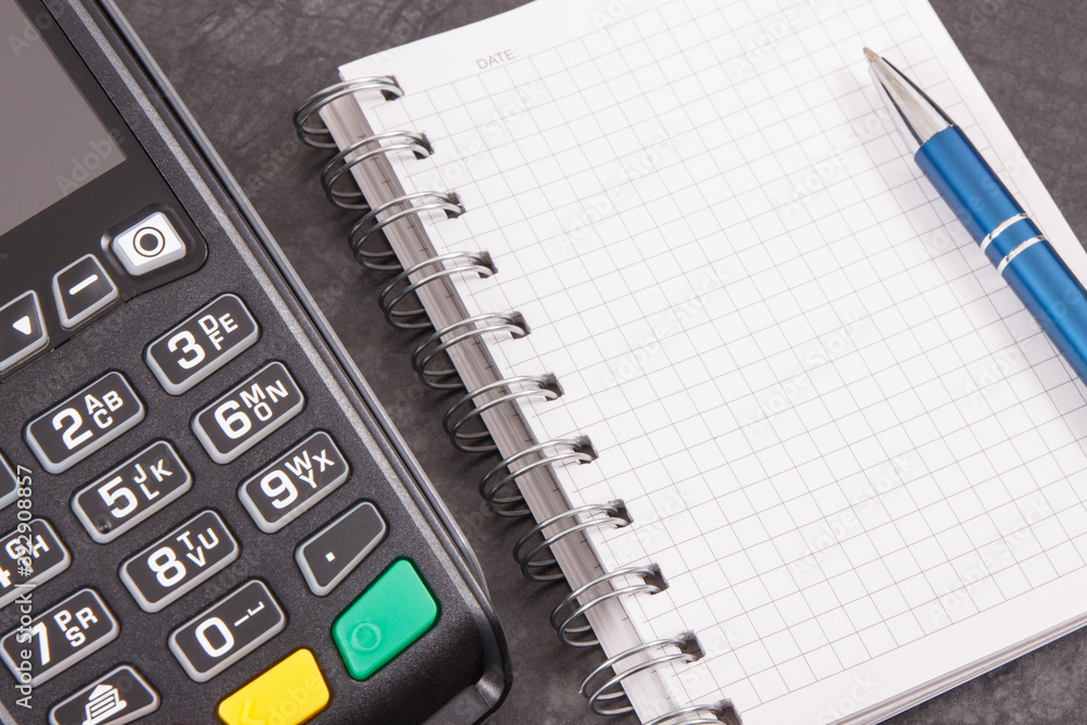 Payment terminal with notepad for writing notes. Business concept. Copy space for text Payment terminal with notepad for writing notes. Business concept. Copy space for text
