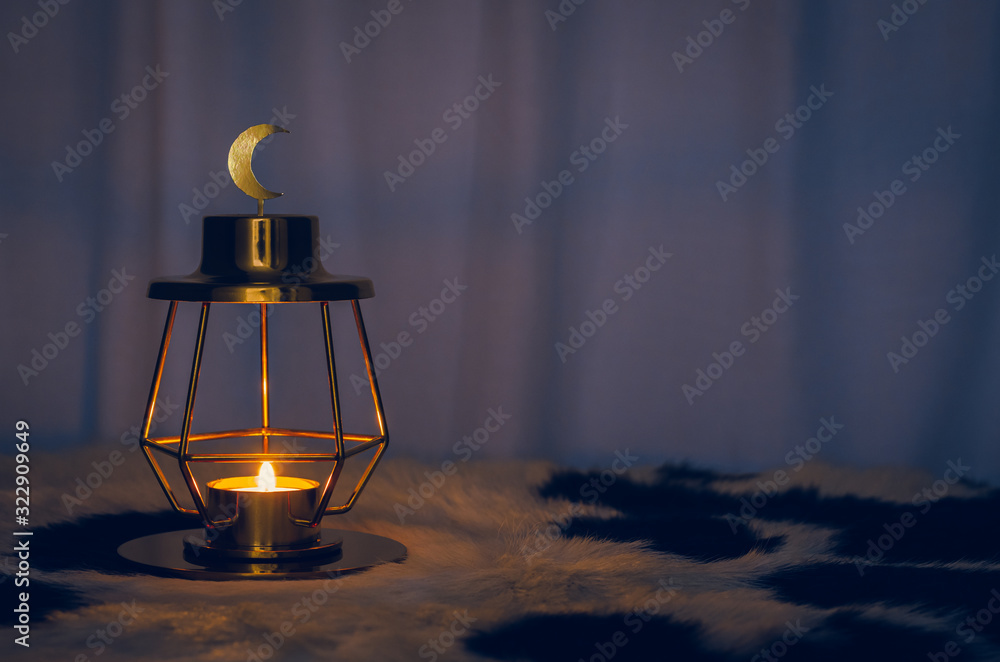Modern golden lantern that have moon symbol on top with dark background for the Muslim feast of the holy month of Ramadan Kareem.