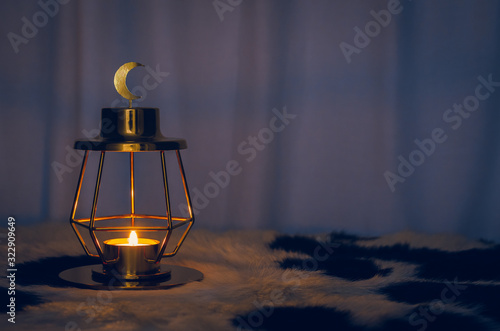 Modern golden lantern that have moon symbol on top with dark background for the Muslim feast of the holy month of Ramadan Kareem.