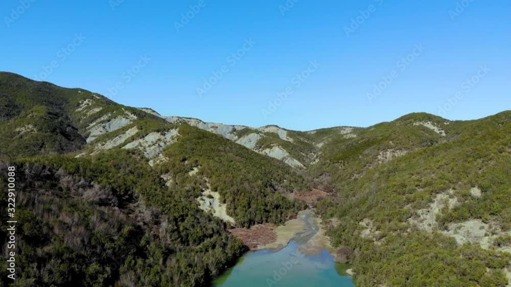 Paradise Alpine valley with calm clear water of lake washing shore of mountains slope with lush vegetation under bright clear blue sky Paradise Alpine valley with calm clear water of lake washing shore of mountains slope with lush vegetation under bright clear blue sky