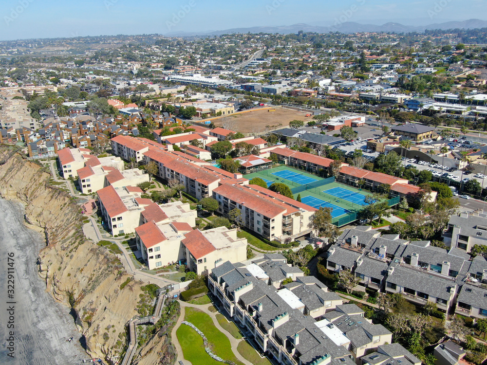 Aerial view of typical south california community condo with tennis court and pool next to the sea on the edge of the cliff during sunny day. Solana Beach. USA