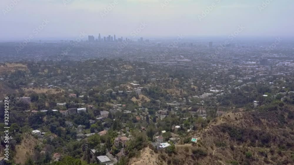 Drone shot moves slowly over suburban sprawl with the silhouette of the downtown Los Angeles skyline in the distance. Drone shot moves slowly over suburban sprawl with the silhouette of the downtown Los Angeles skyline in the distance.