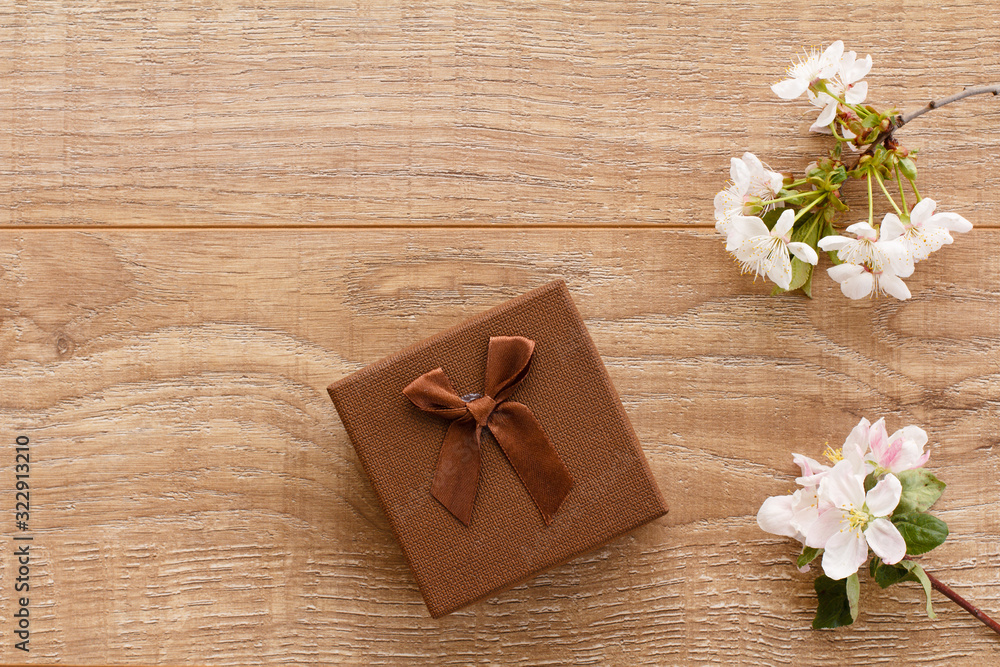 Gift box with cherry flowers on the wooden background. Gift box with cherry flowers on the wooden background.