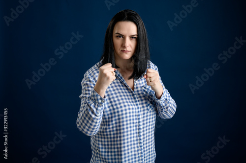 Young woman dressed casually shows his fist and get angry