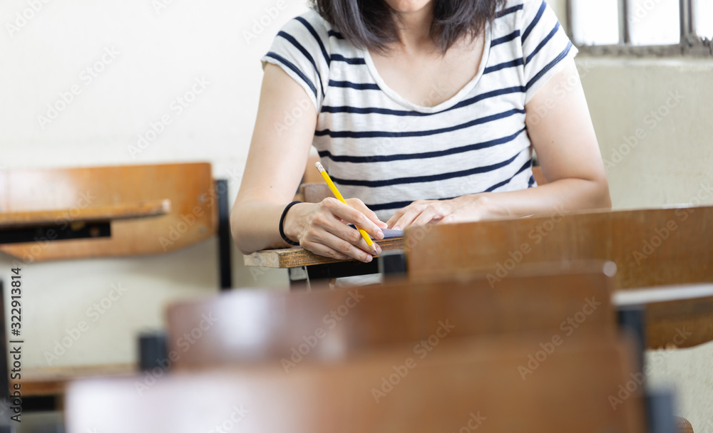 high school,university student study.hands holding pencil writing paper answer sheet.sitting lecture chair taking final exam attending in examination classroom.concept scholarship for education abroad high school,university student study.hands holding pencil writing paper answer sheet.sitting lecture chair taking final exam attending in examination classroom.concept scholarship for education abroad