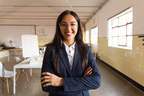 Confident smiling Asian businesswoman with crossed arms. Beautiful young woman in eyeglasses looking at camera. Business concept photo