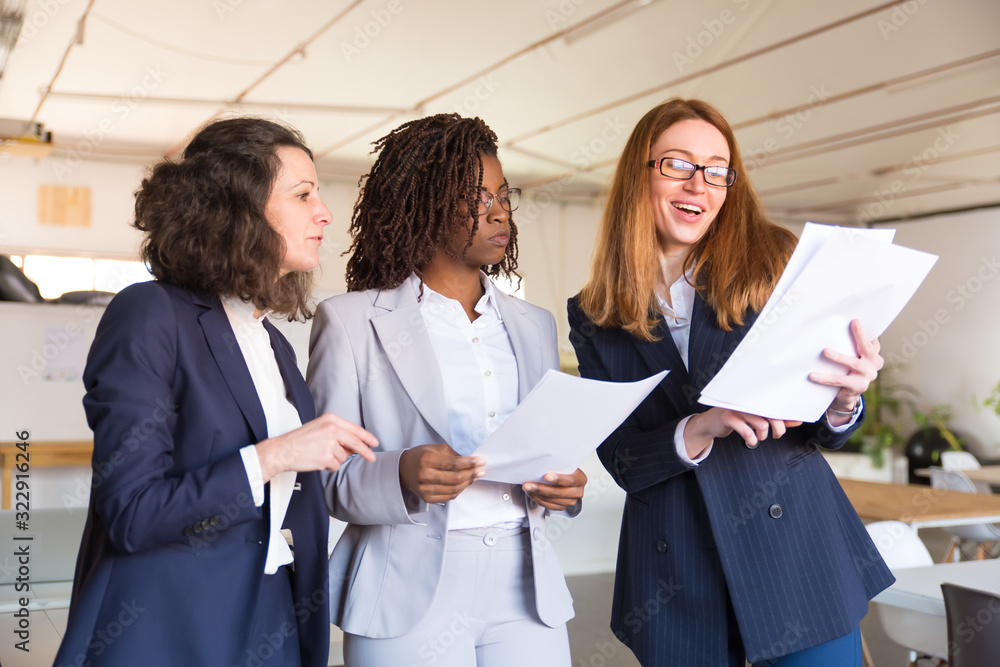 Group of focused women studying new project. Front view of professional business team with instructions. Business concept
