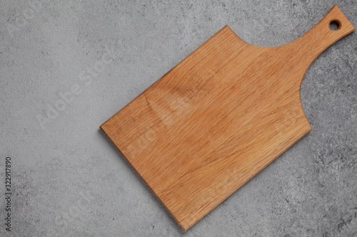 Wooden cutting board on grey stone table. Cutting board on kitchen table. Top view copy space. 