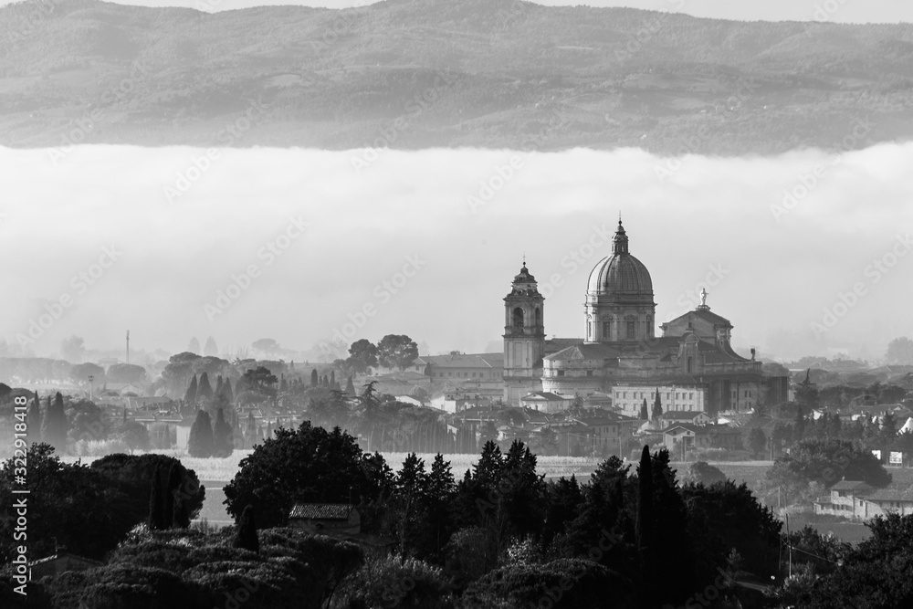 Surreal view of Santa Maria degli Angeli papal church (Assisi) on a background of fog