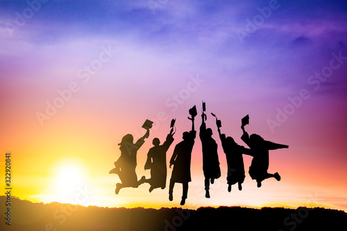 The Silhouette of  graduation group celebrating and jumping on mountain photo