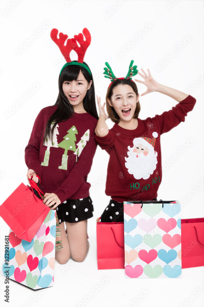 Studio portrait of two young women carrying shopping bags,christmas concepts. Studio portrait of two young women carrying shopping bags,christmas concepts.