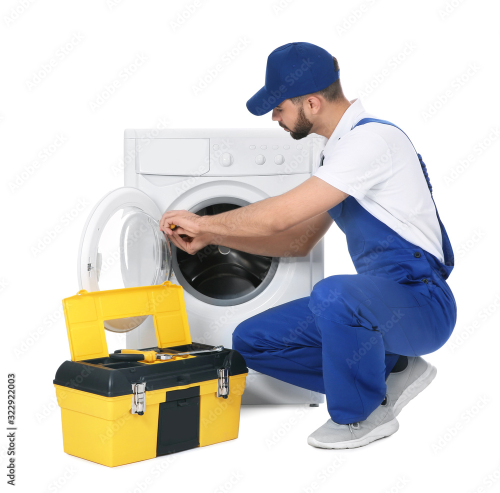 Plumber repairing washing machine on white background