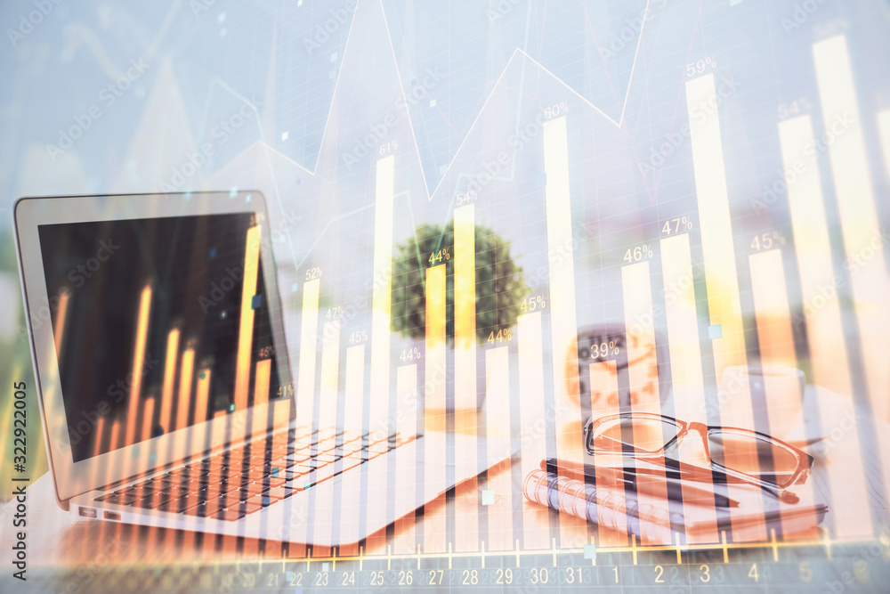 Forex graph hologram on table with computer background. Multi exposure. Concept of financial markets. Forex graph hologram on table with computer background. Multi exposure. Concept of financial markets.