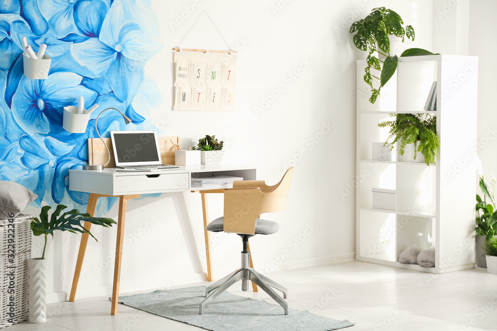Fototapeta premium Stylish living room interior with blue flowers painted on wall. Floral pattern
