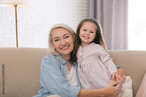 Happy granddaughter and grandmother together at home