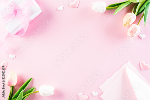 International Women's Day concept. Pink and white tulips with gift box and paper tag text on pink pastel background. Top view flat lay, March 8.