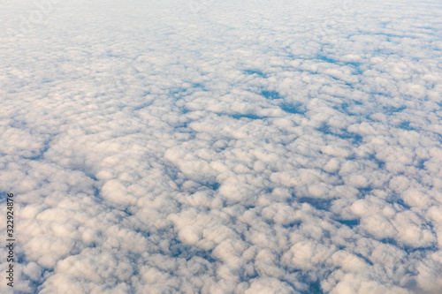 Aerial view of fluffy clouds through an airplane window