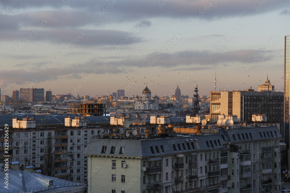Sunset panorama of Moscow with birds in the sky, winter time