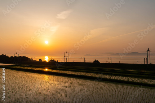 オレンジ色の日の出と水田と琵琶湖と線路 © sigmaphoto