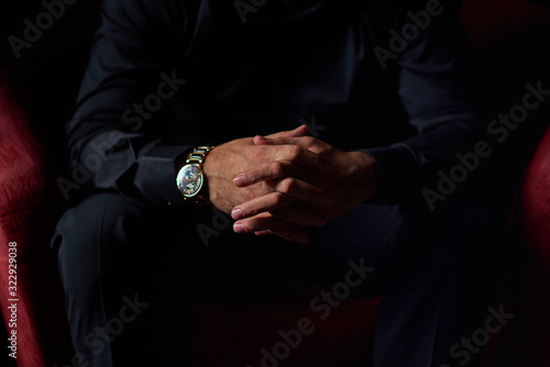  male businessman sitting on an armchair with a laptop in his hands on a black background