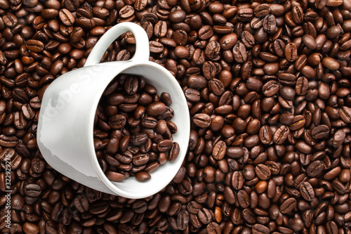 White cup with coffee beans on a background of coffee beans