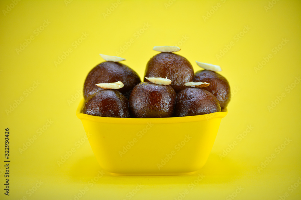 Obraz premium Indian dessert gulab jamun served in yellow bowl