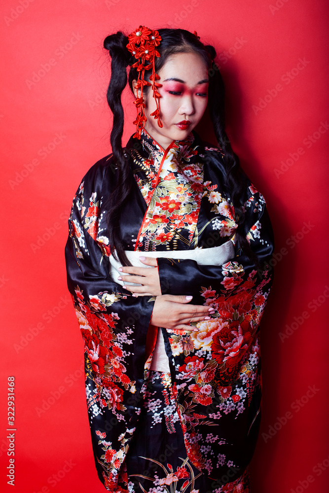 young pretty geisha on red background posing in kimono, oriental concept young pretty geisha on red background posing in kimono, oriental concept