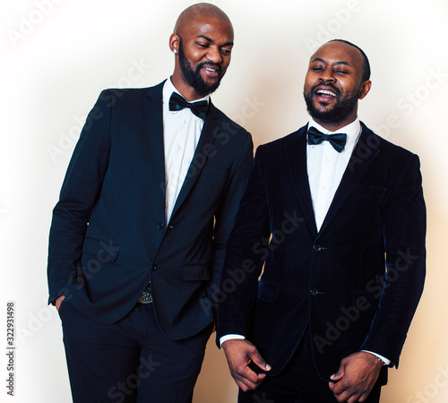 two afro-american businessmen in black suits emotional posing, gesturing, smiling. wearing bow-ties entertaiment stuff photo