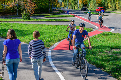 Radfahrer befahren einen Übergang von der Straße auf einen kombinierten Rad- und Fußweg photo