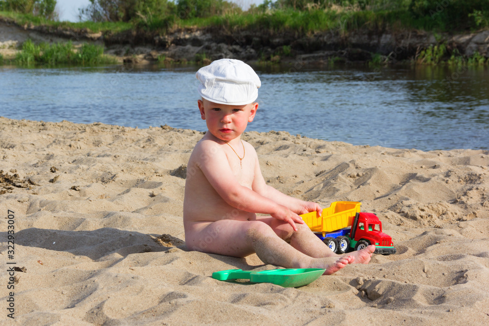 Cute baby boy playing with beach toys on tropical beach Cute baby boy playing with beach toys on tropical beach