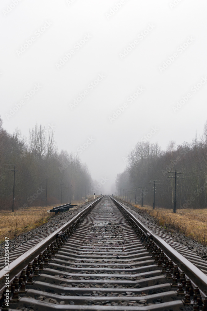 Railroad track going far in the cold mist Railroad track going far in the cold mist
