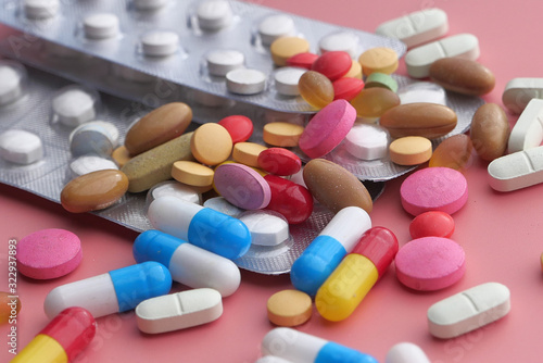 colorful pills and capsule on color background, close up 
